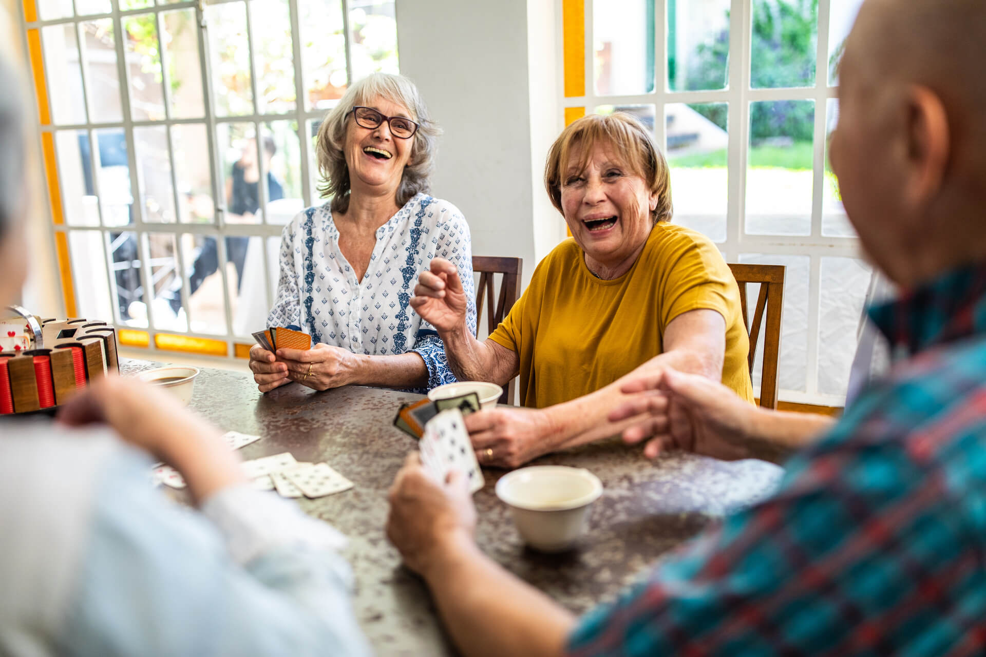 elderly gathering at a table laughing
