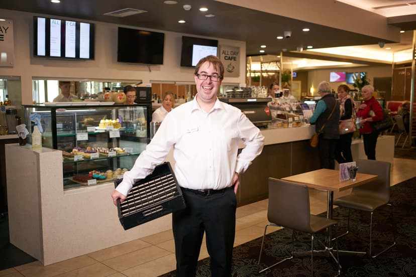 Pat holding a tray in cafe