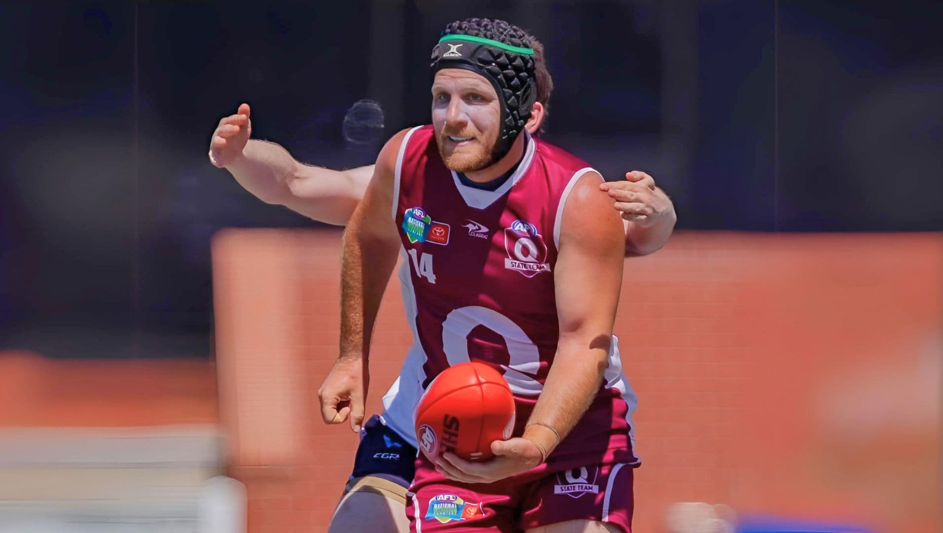 SEQ Inclusive League player ready to handball a footywinners celebrate in a team photo