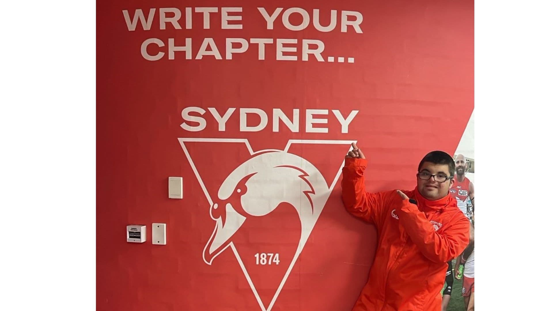 Adam points to a wall printed with the words Write your own chapter...