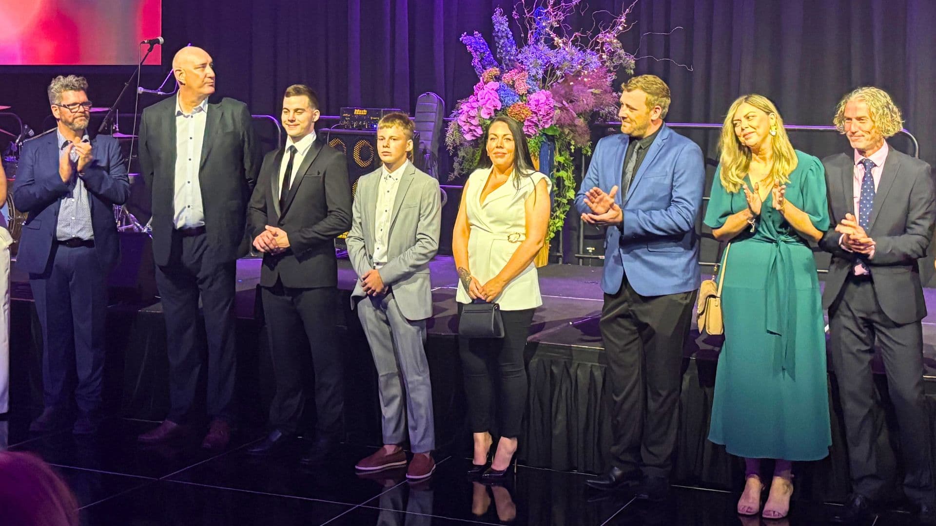 Award finalists line up by a stage