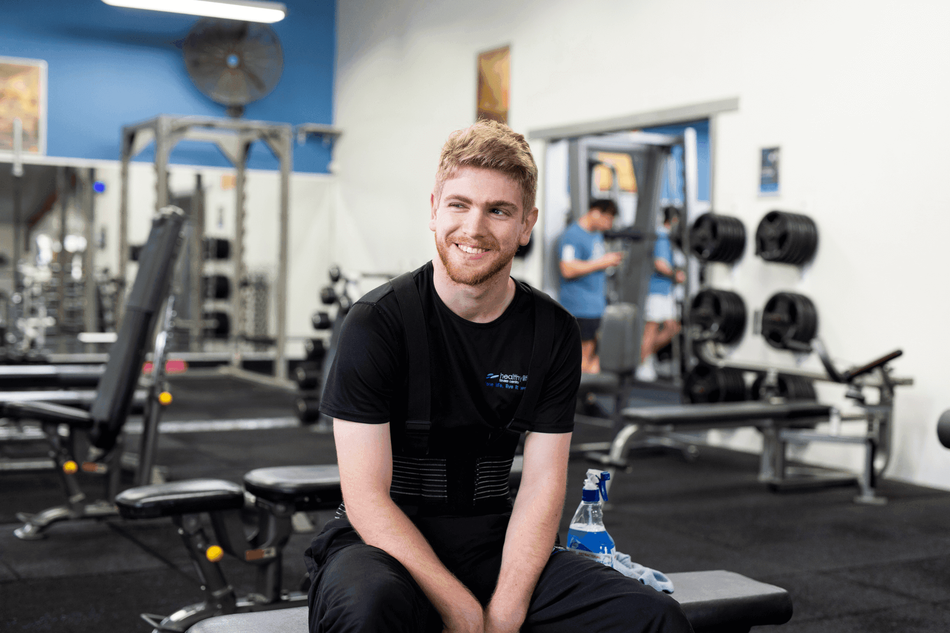 man sitting at a bench in the gym