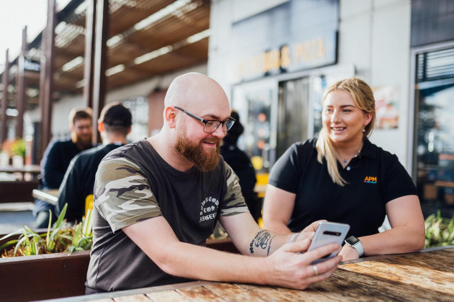 APM Employee discussing with a man while hes texting