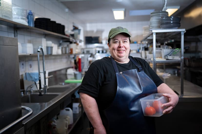 Participant Melissa in a cap and apron in a kitchen 