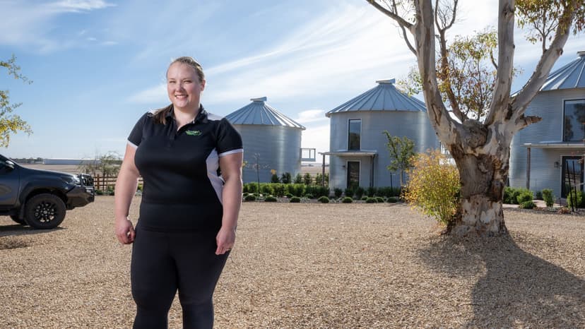 Inclusive employment participant Ngaire in a black top outside rural buildings where she works.