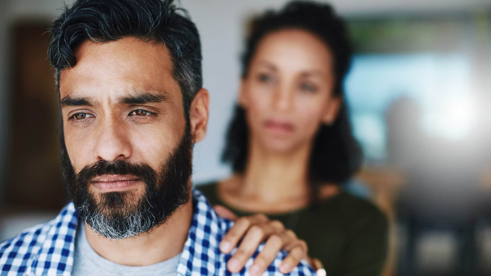 A man and his wife, who is concerned about his wellbeing, looking to support him through his depression