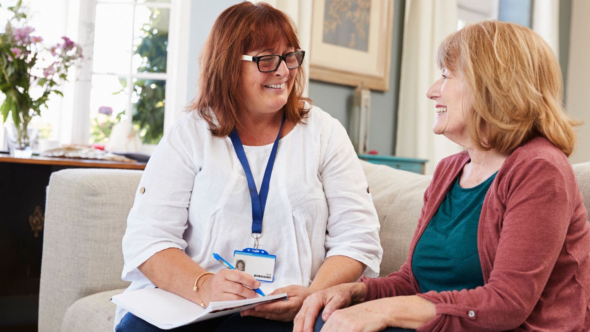 A disability support worker sits with a client