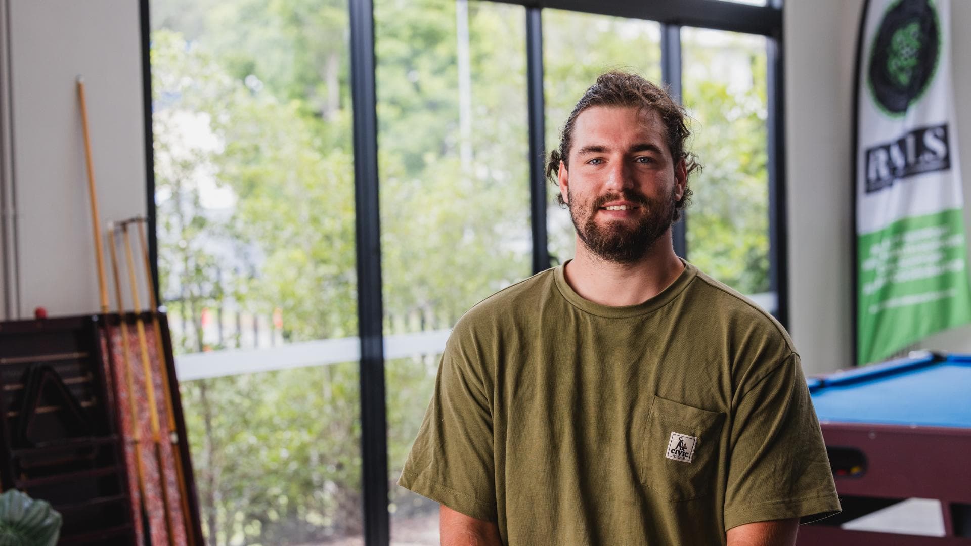 A young man in a green top is part of the Workforce Australia supported RAILS program.