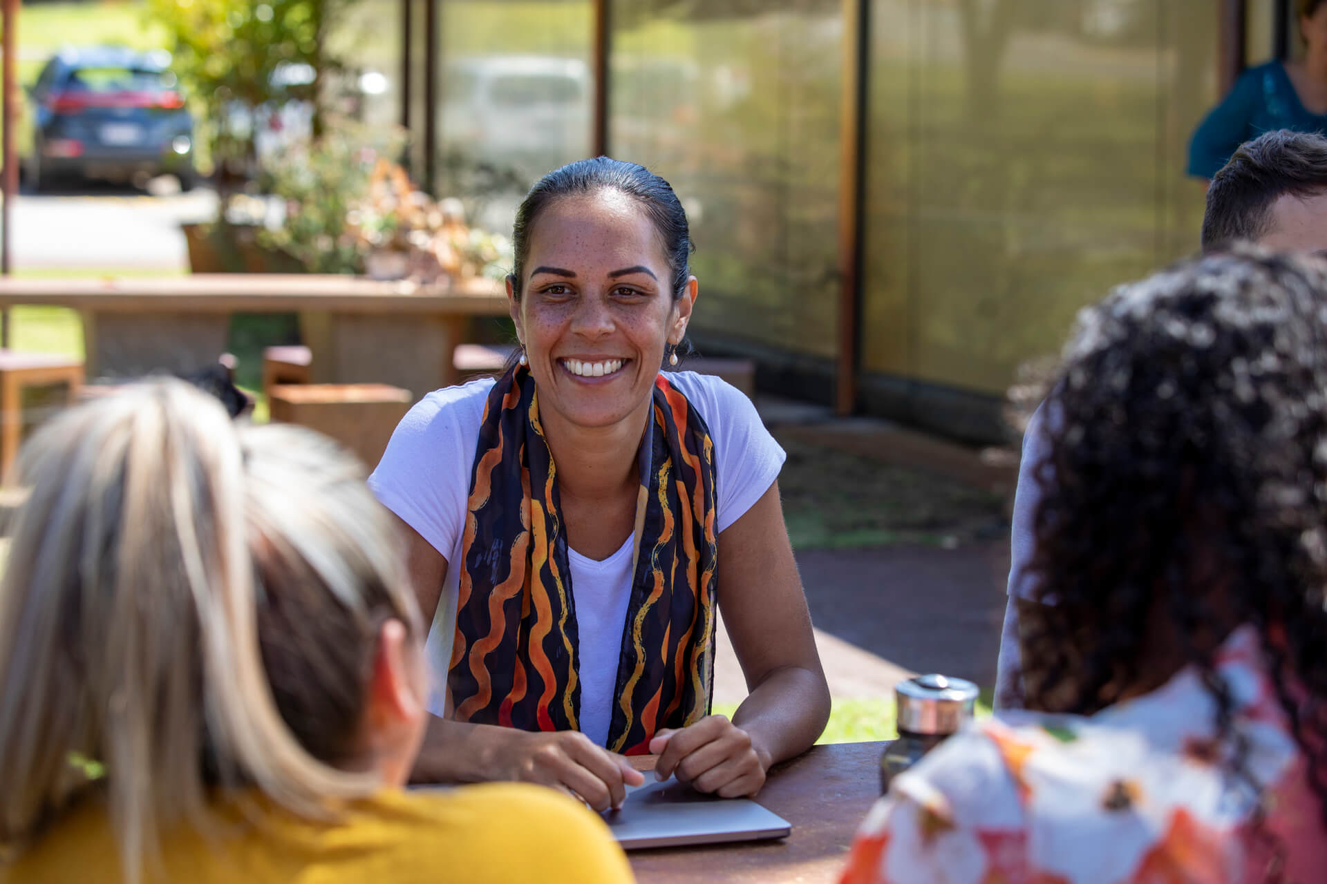 Smiling woman discussing job ideas for introverts living with ADHD with friends at a table.