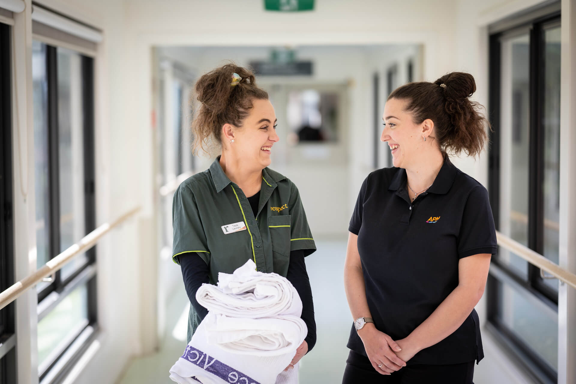 DES participant Tayla talking to an APM consultant in a corridor