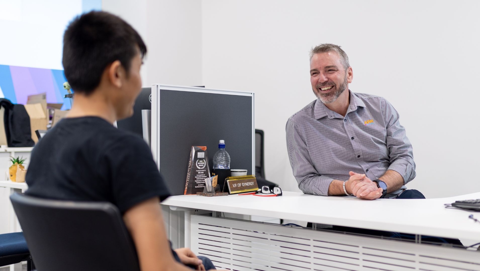 Paul from APM smiles with Sajad in an APM Employment Services office.