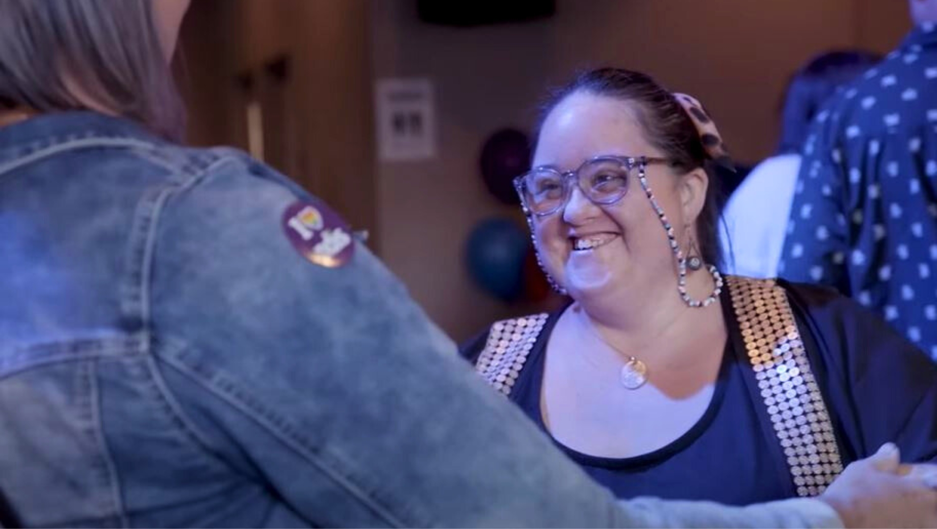 A young woman smiles dancing at the disability inclusive EasyBeatz disco