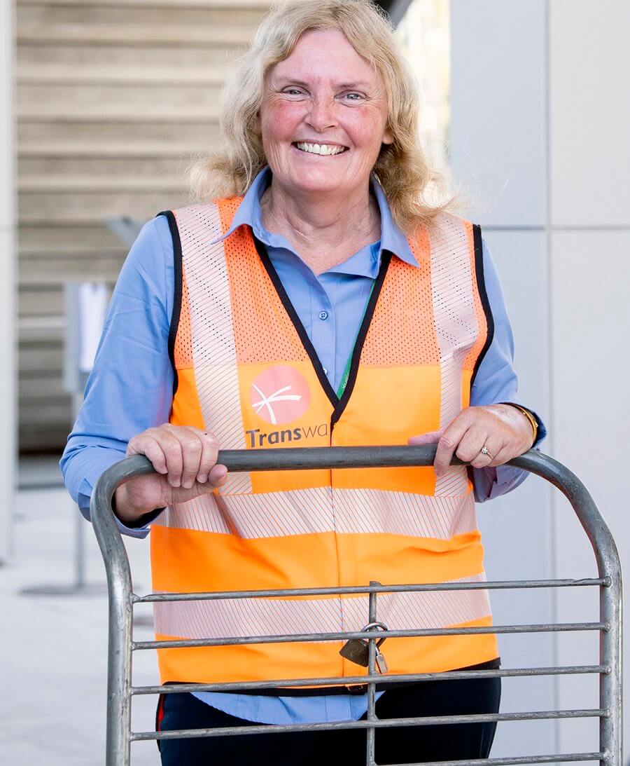 Smiling TransWA worker pushing a trolley