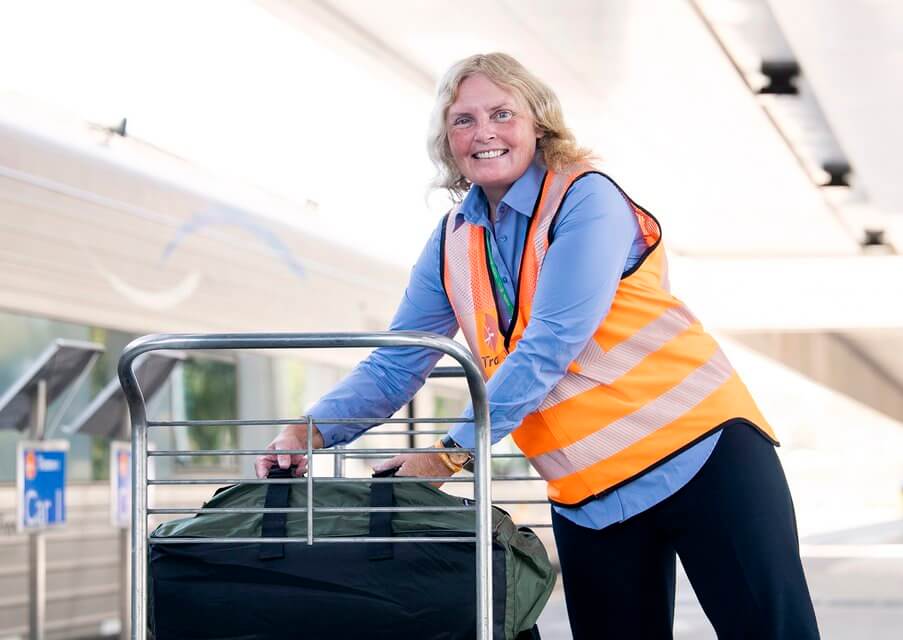 woman moving bags in a high visibility vest