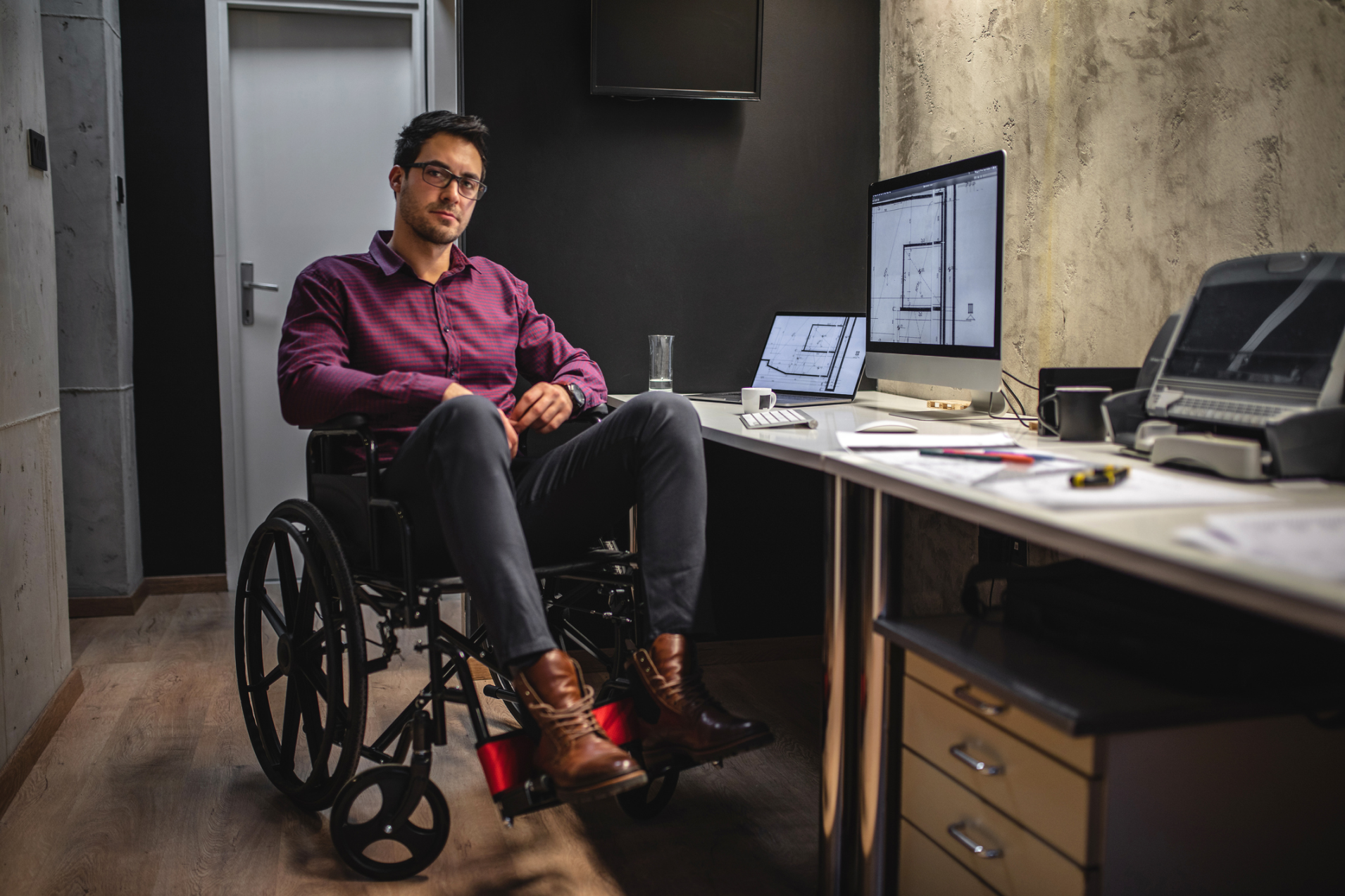 Man in a wheelchair sitting in front of an office work station
