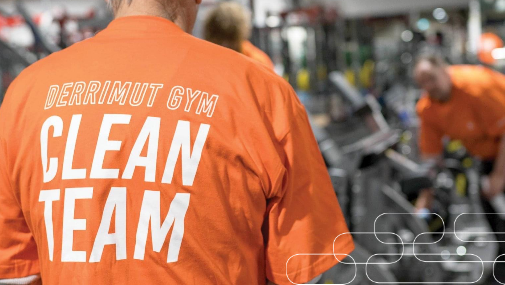 A man wearing an orange t-shirt with the words "of the Derrimut clean team" on it
