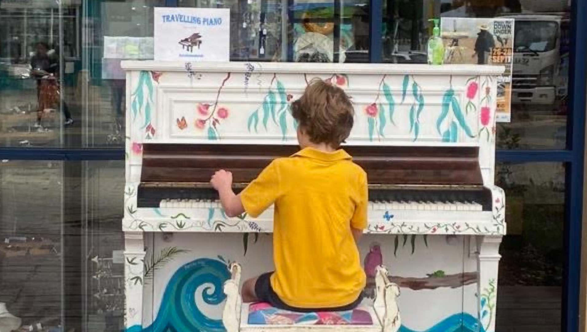 Charlie sitting at the "Travelling Piano" on the Mandurah foreshore, playing enthusiastically