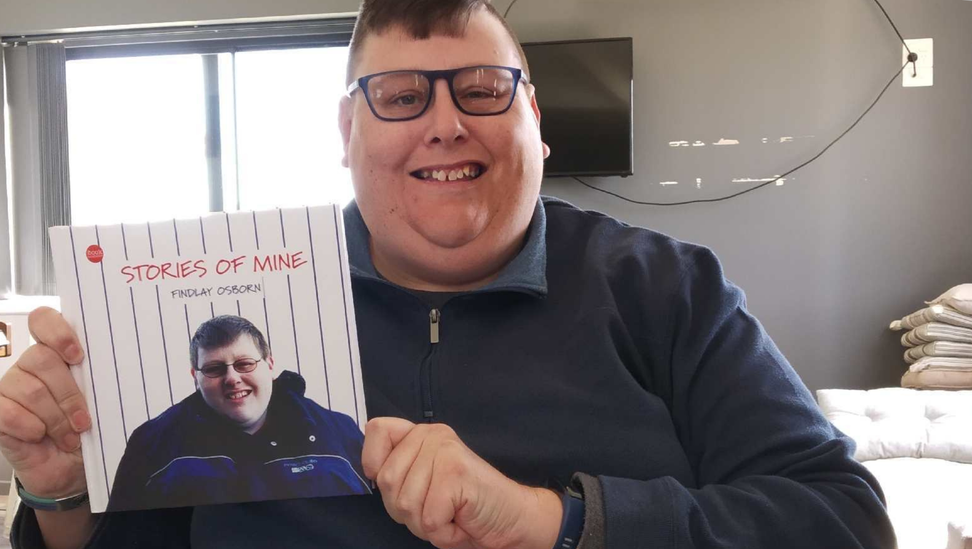 Findlay proudly holding his book, authored by him, about his life