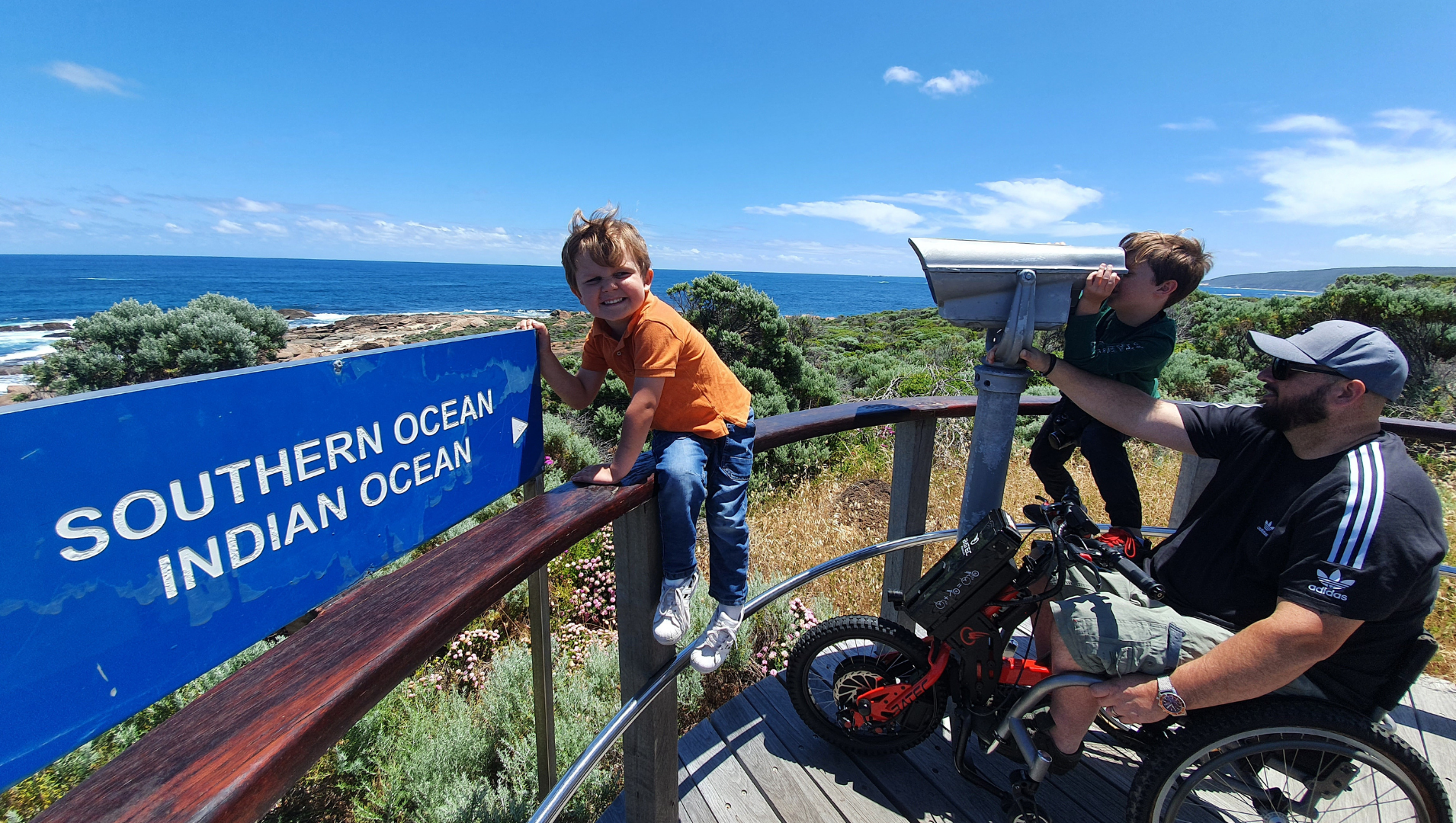 Andrew Hartshorn pictured with his two sons at a beach lookout point in Cape Leeuwin