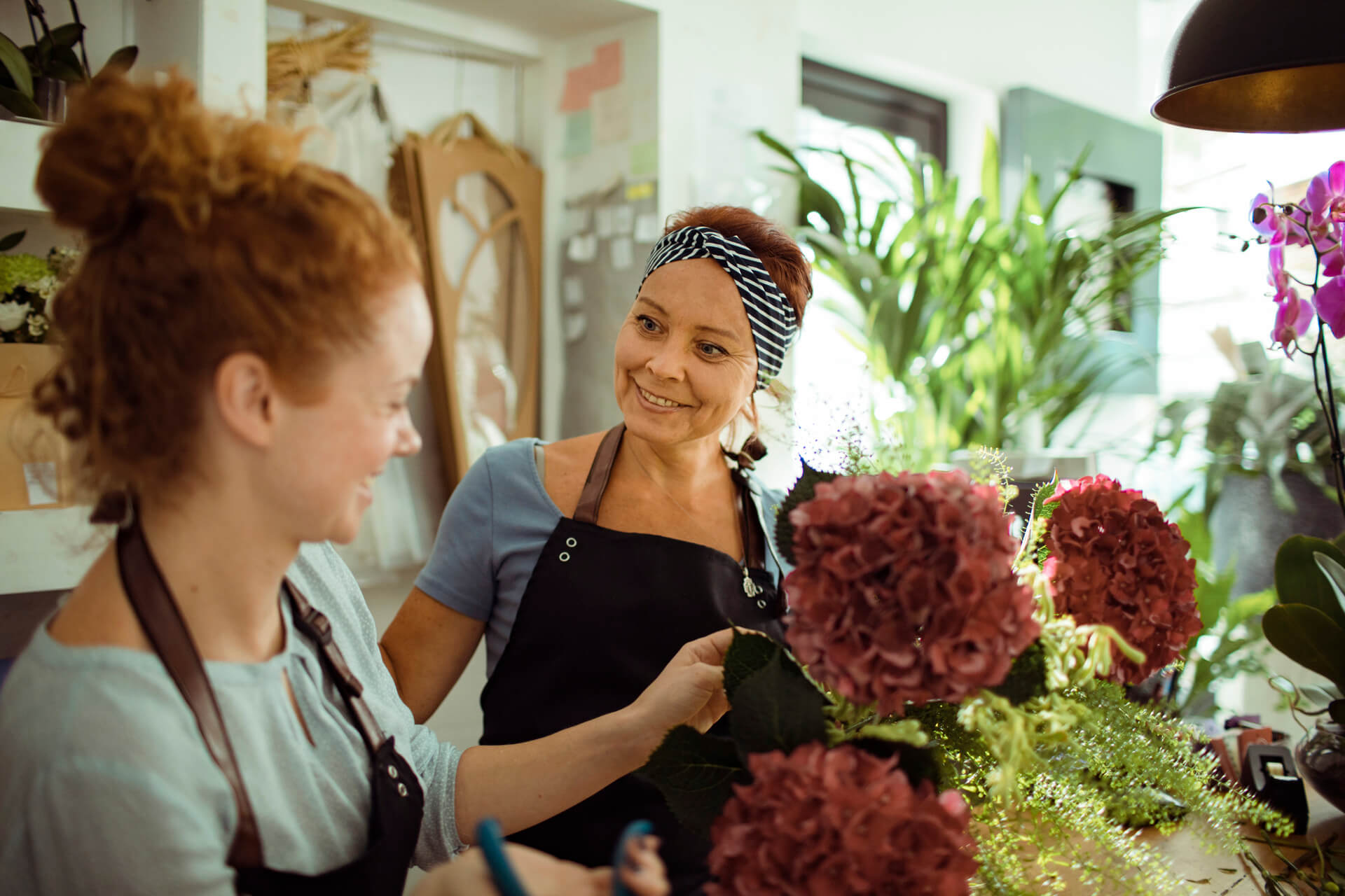 Woman with Parkinson's talking to colleague at new job at florist