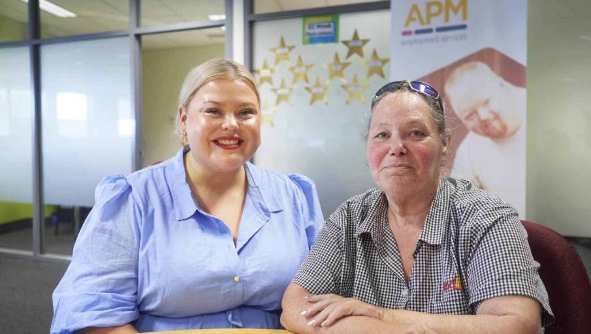 Kellie is sitting on the right hand side of her APM Employment consultant, Paris, they are both seated inside an APM office