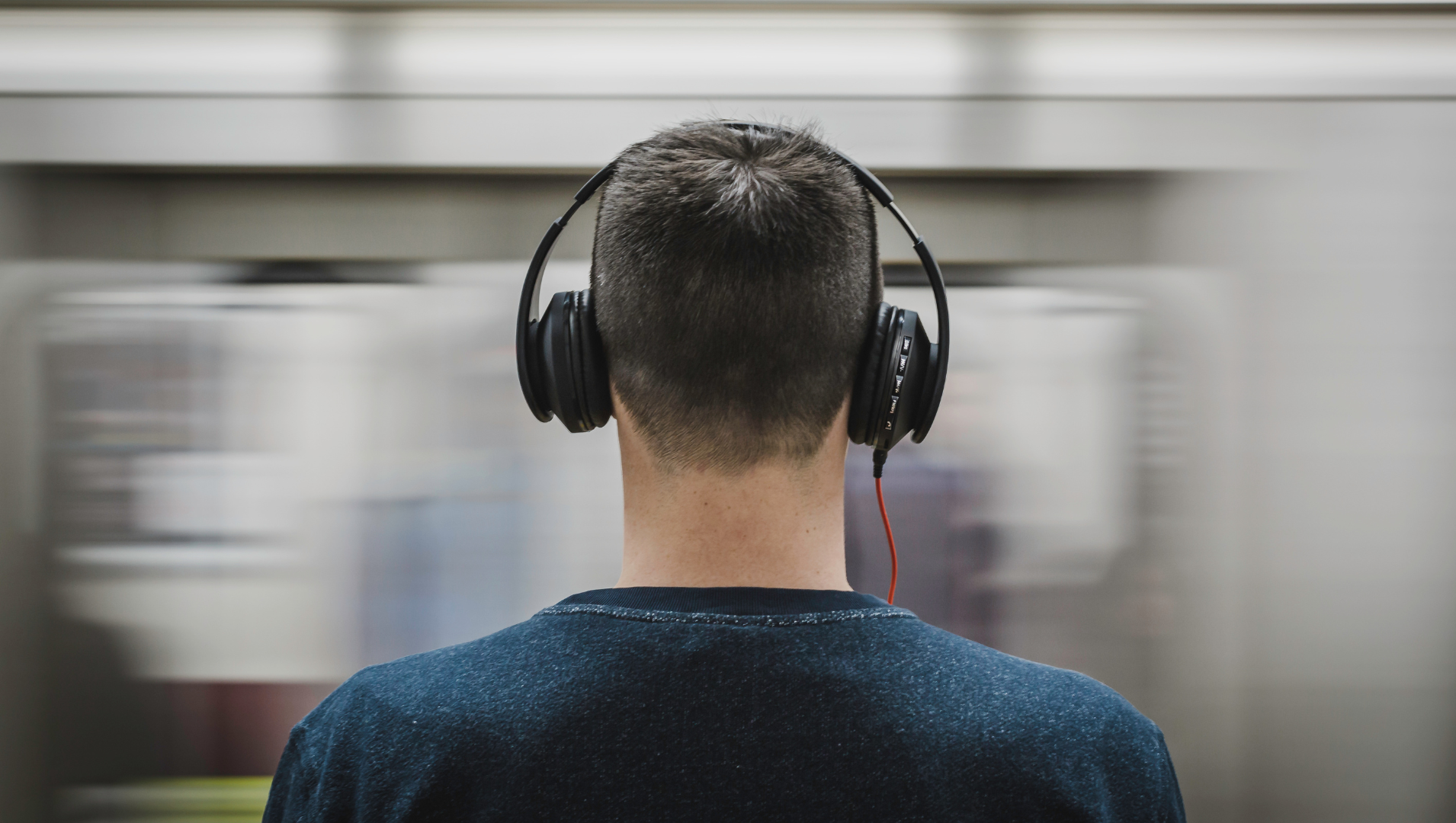 Man wearing noise cancelling headphones amidst a busy environment