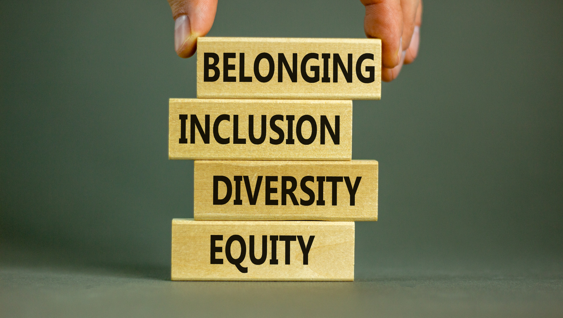 4 stacked wooden blocks with belonging, inclusion, diversity and equity written on them