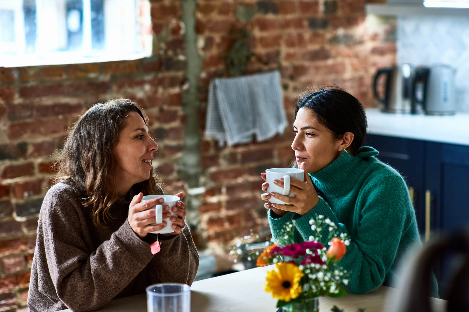 Two friends supporting each other through depression with a warm mug of coffee