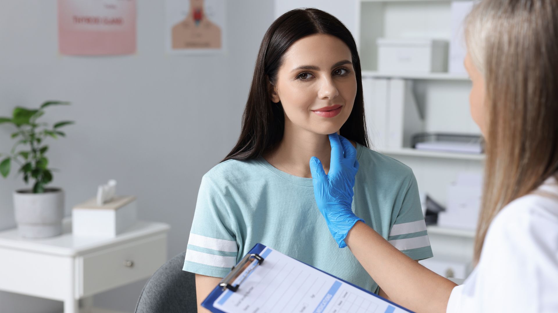 A woman has her thyroid examined by a doctor in a medical clinic