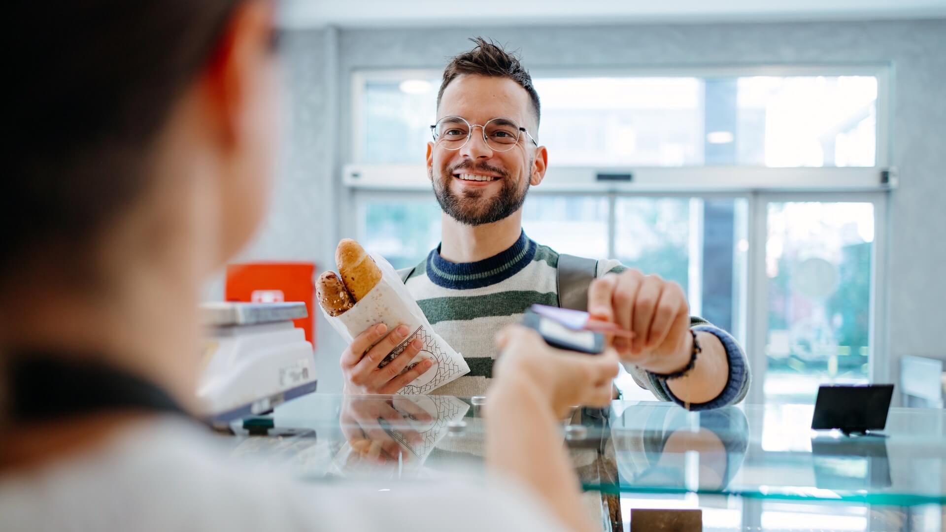 A man paying for bread by card at a bakery