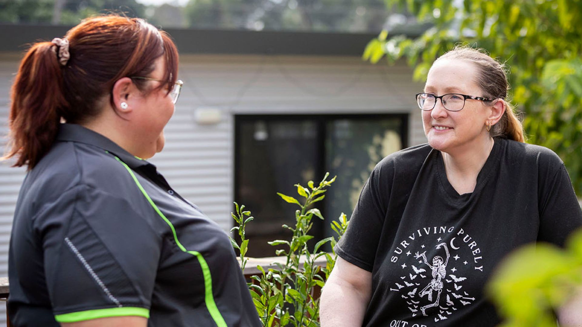 Nikki and Jodie talking together on an outdoor deck during a home support visit.