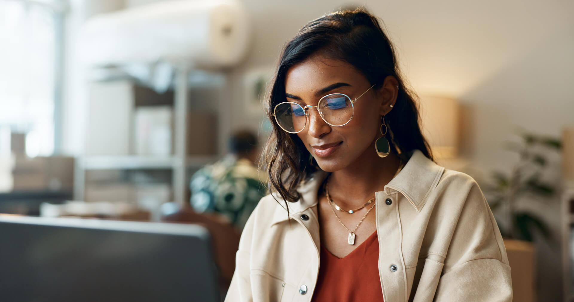 A woman wearing glasses working on a computer