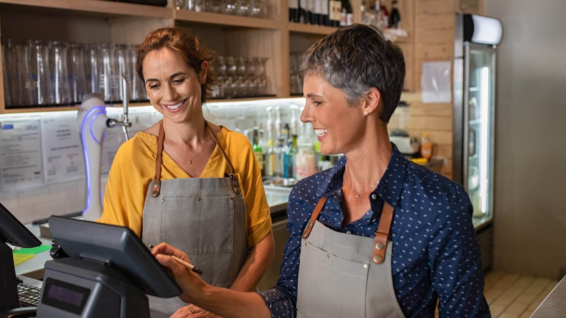 Two café workers standing at the till