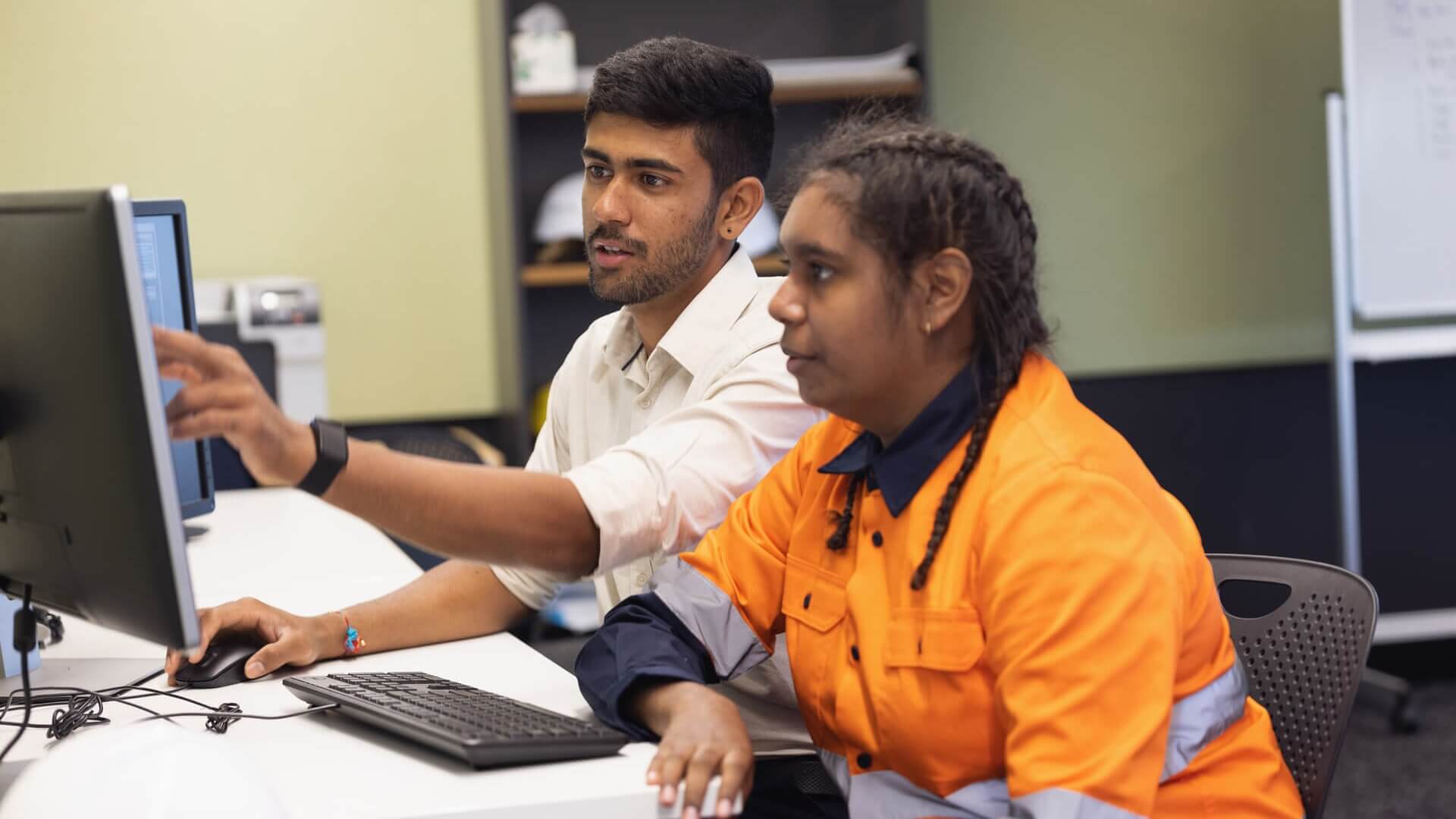 Two people discussing work at a computer