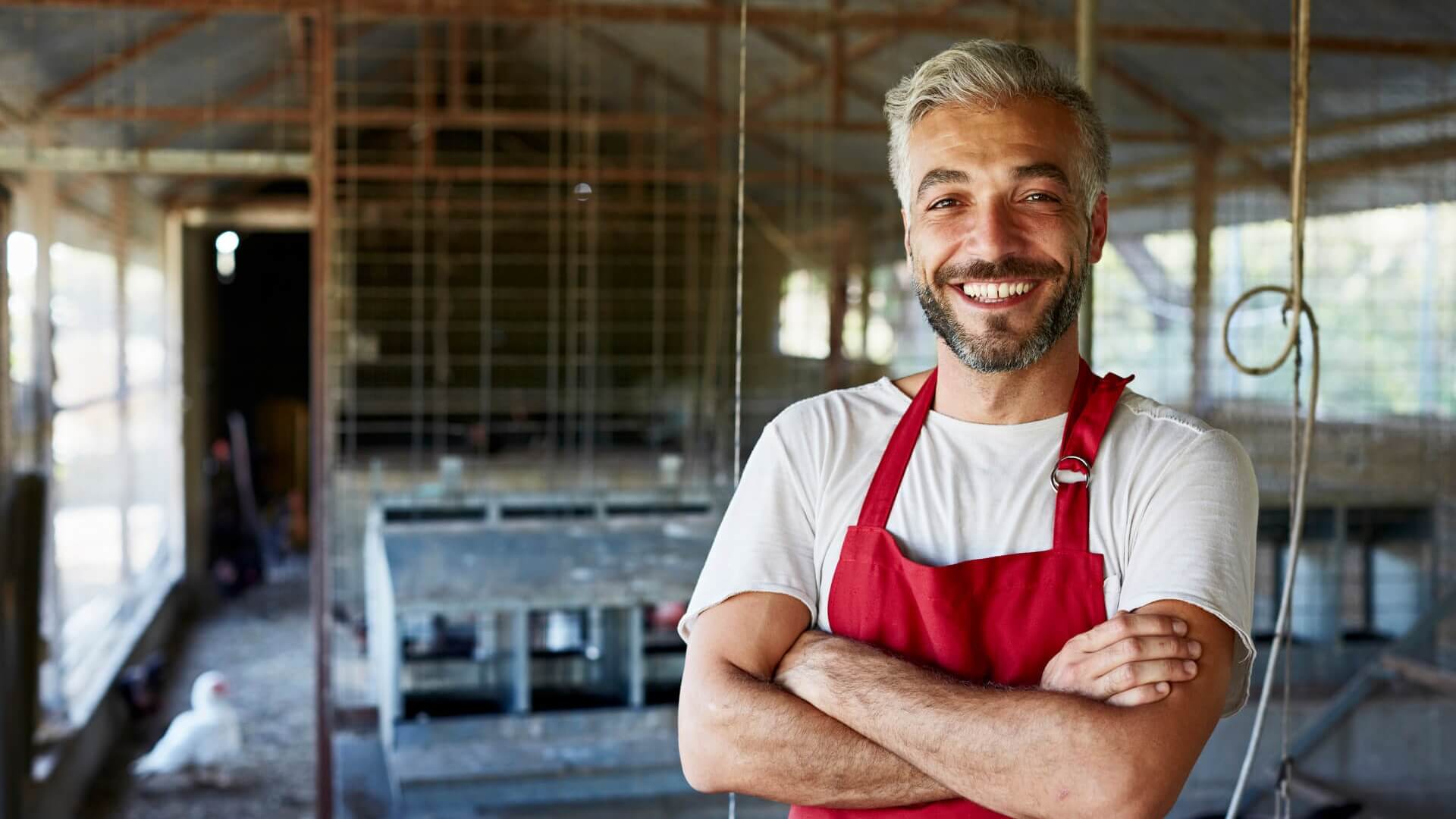 A smiling chicken farmer