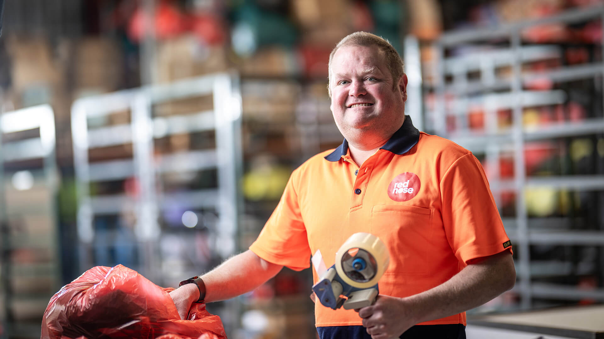 DES participant Eric in an orange top in a warehouse 