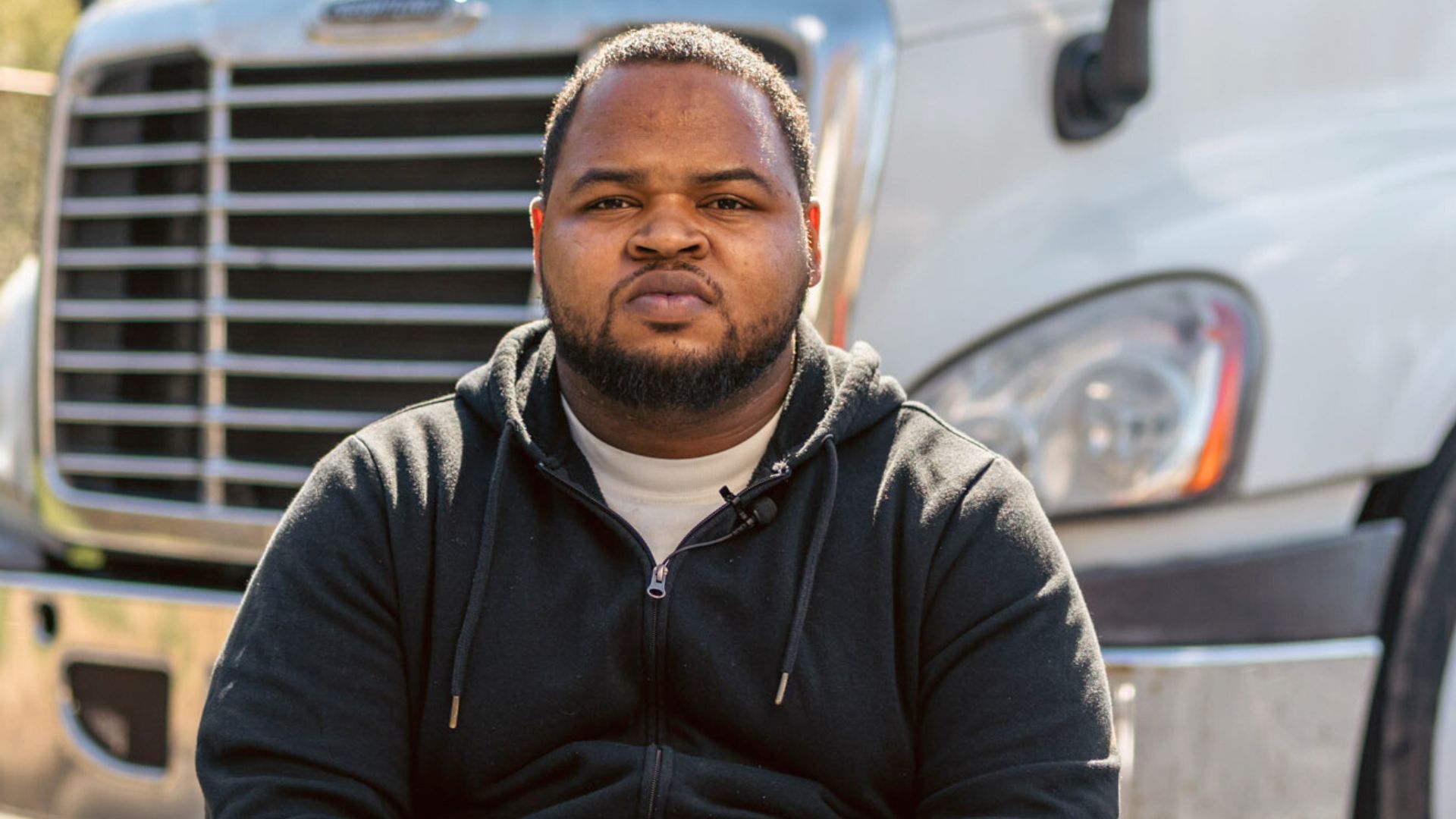 Kion from the Ross Career Advantage Program seated outdoors in front of a white commercial truck.