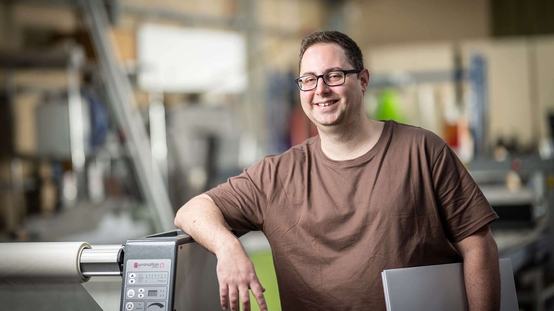 Man smiles in brown tshirt