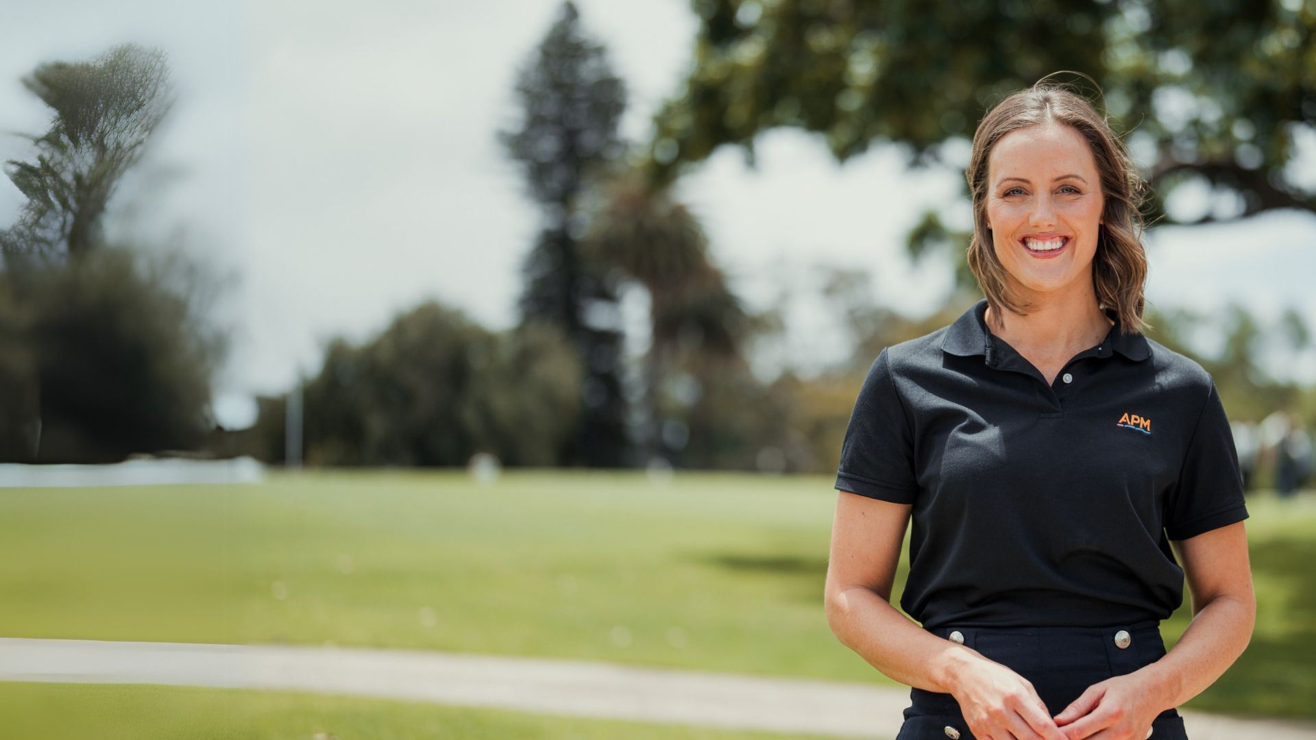 Ellie Cole in a park wearing an APM polo