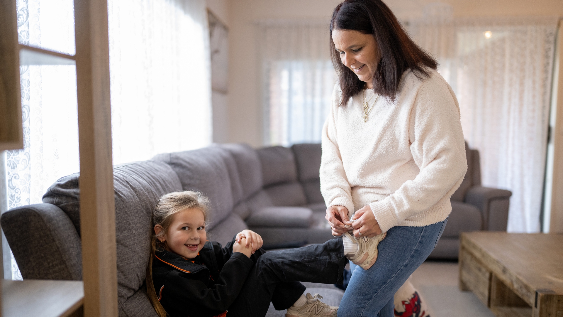 Nicole helping her daughter prepare for the day at home, reflecting the positive impact meaningful employment has had on her family and future through support from Inclusive Employment Australia and APM Employment Services.