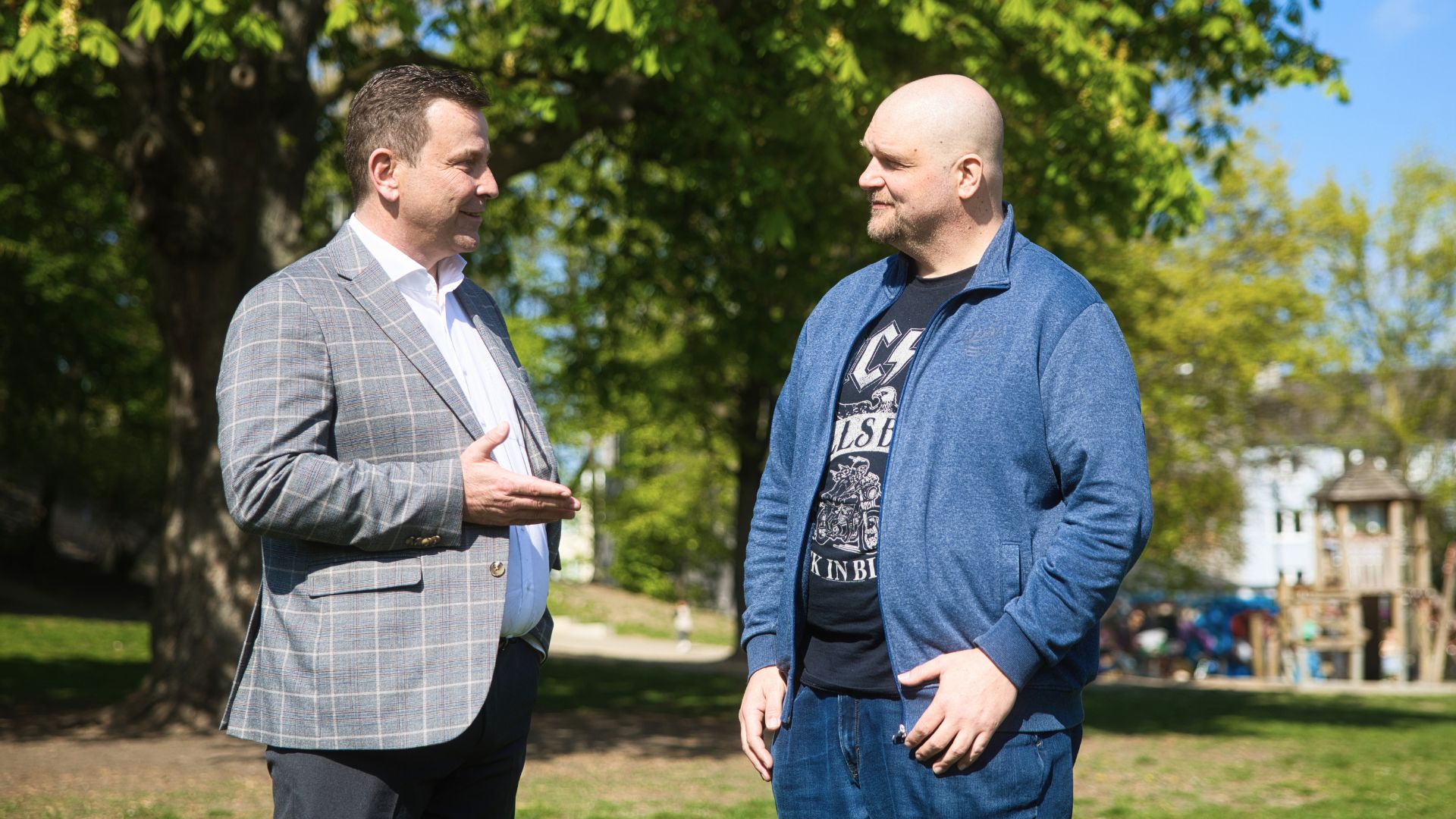 Marcel having a conversation with another person in a park, illustrating the guidance received from Ingeus Germany.