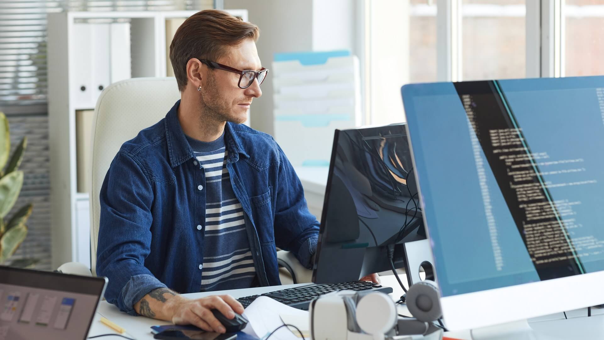 A man working on a computer in an open plan office