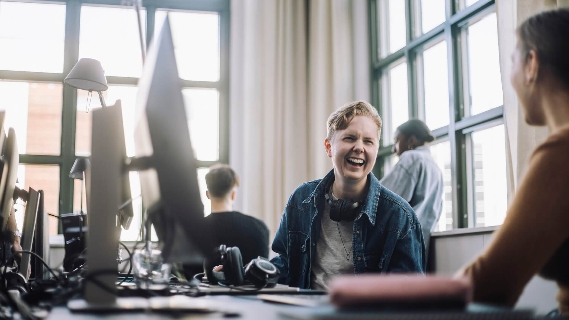 Two colleagues chatting at their desks