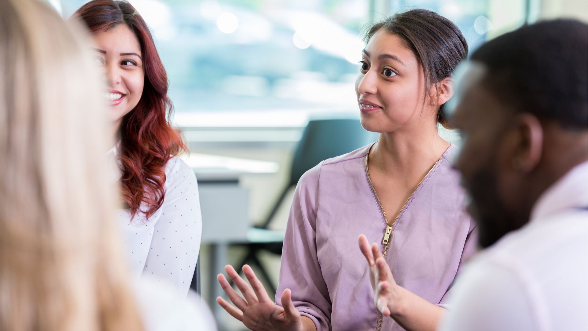 A smiles in conversation with work colleagues about hypothyroidism