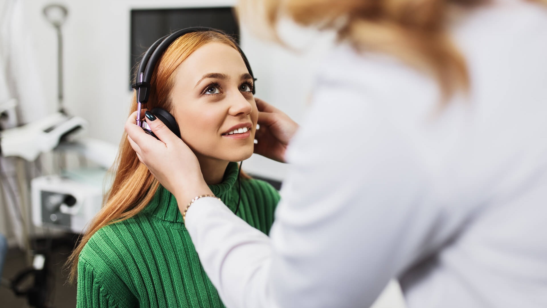 A woman being fitted with headphones