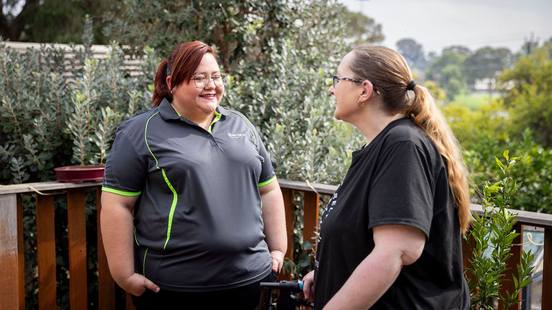 Nikki and Jodie talking together on an outdoor deck during a home support visit.