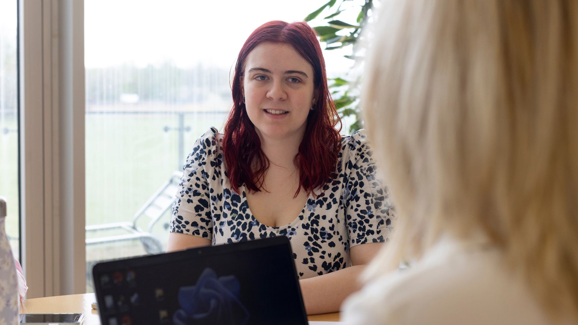 Individual in a workplace meeting discussing mental health accommodations for living with schizophrenia.