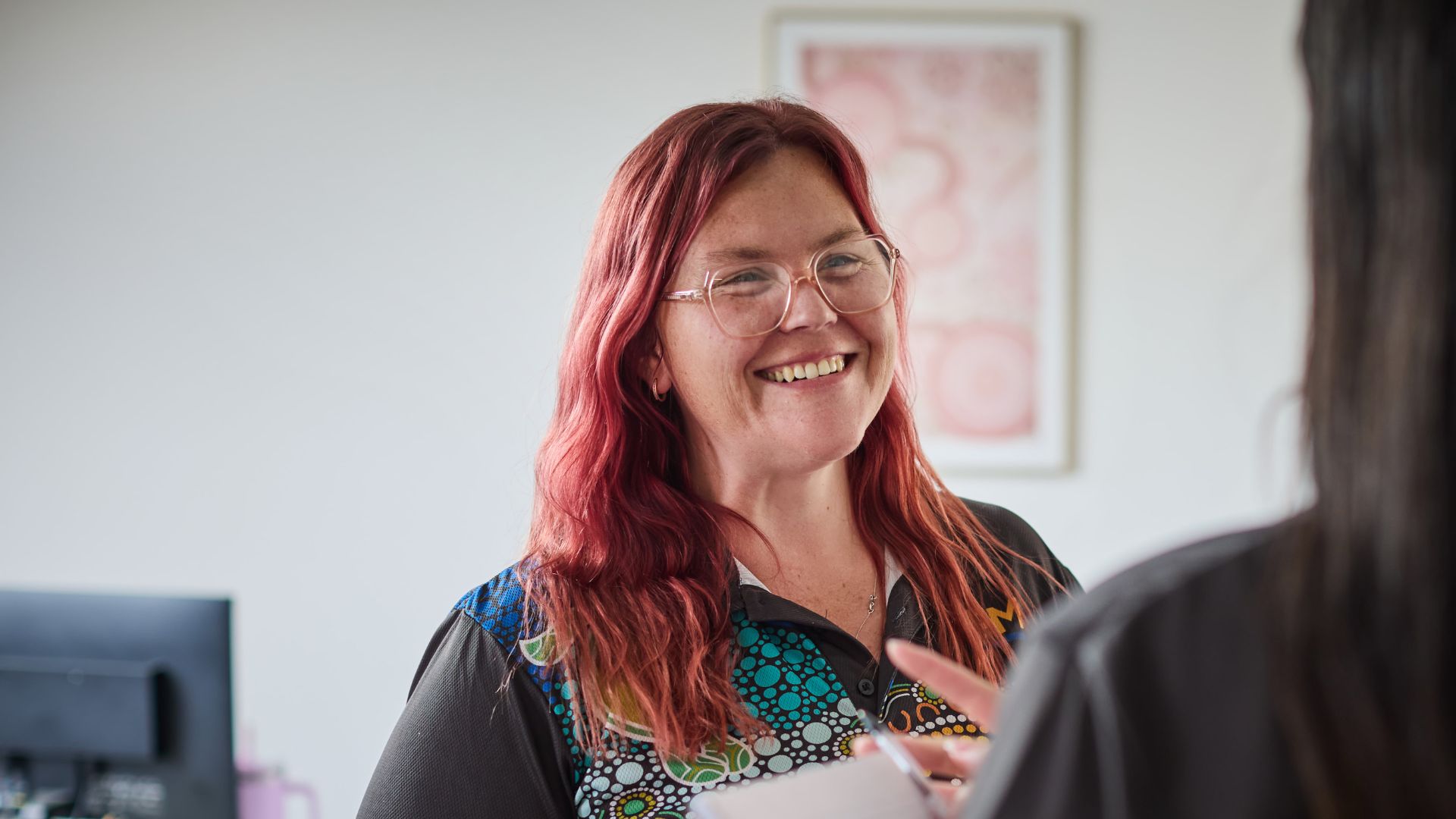 Clare smiling in a First Nations APM top