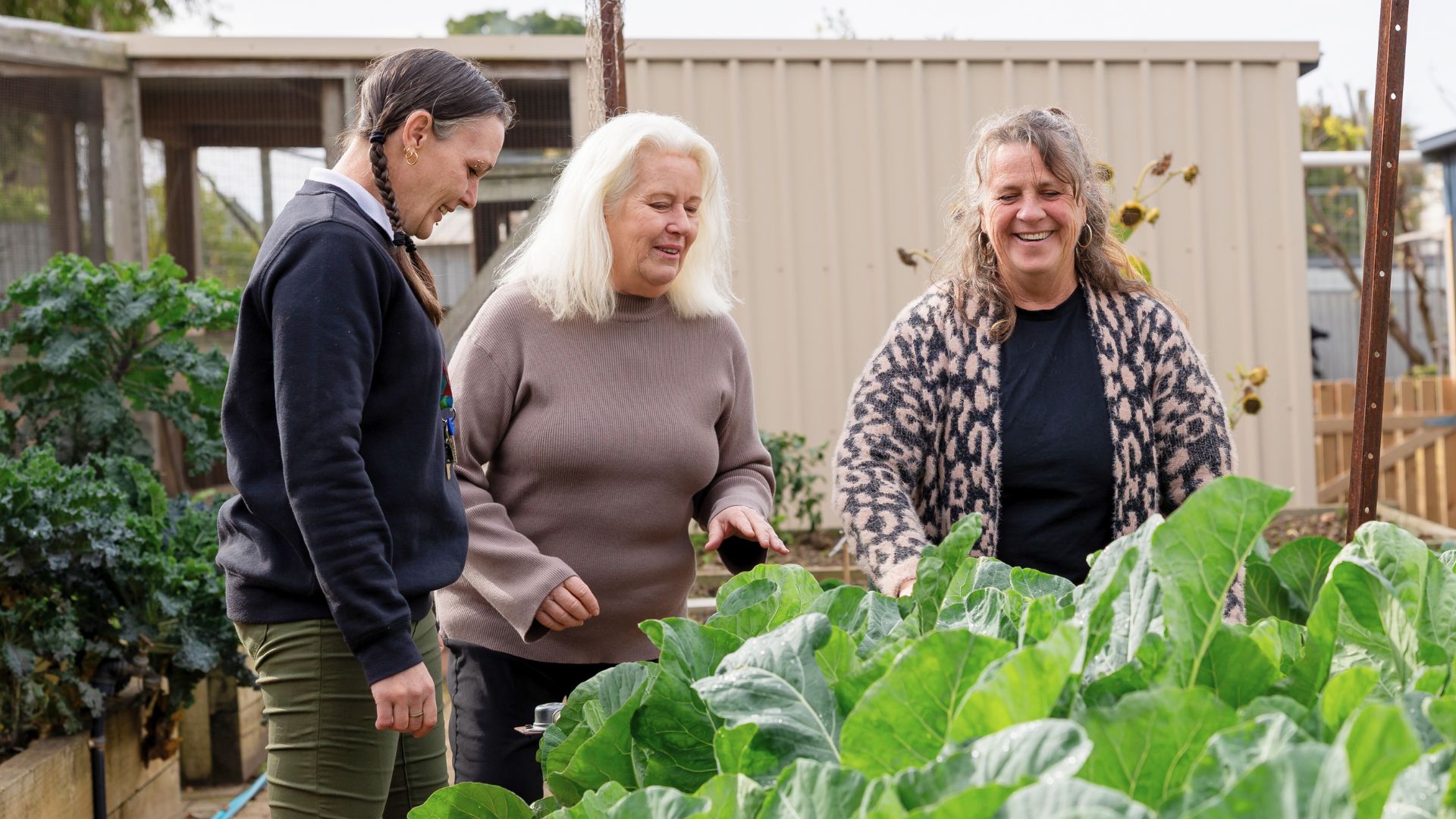 Kylie participating in an outdoor garden activity with others