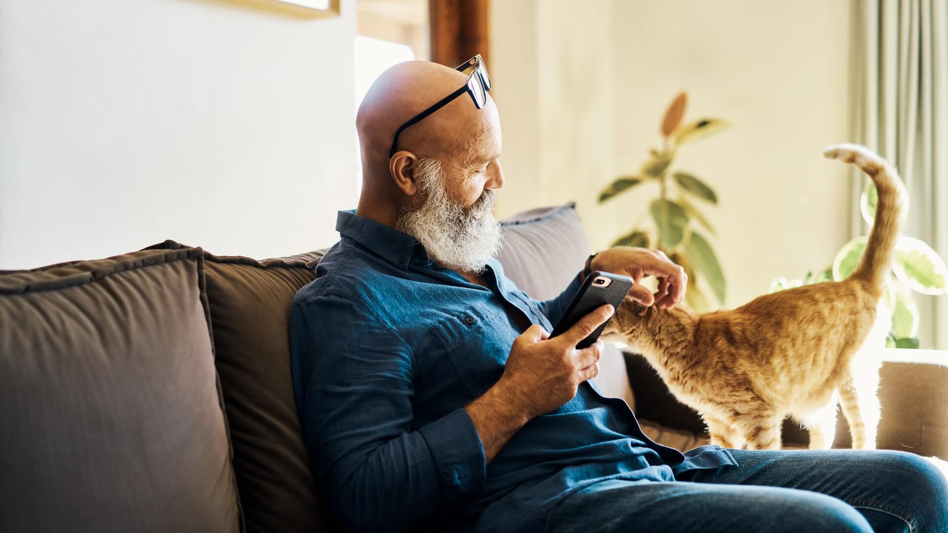 A man sitting on the couch at home with his cat